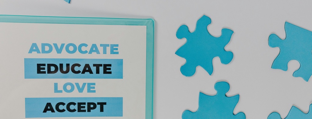 A banner with blue autism puzzle piece, and the words "Advocae, Educate, Love, Accept"
